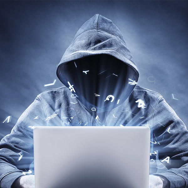 Ransomware Data Recovery: cybercriminal hoodie hacking behind laptop